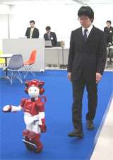 En vidéo : Emiew 2, le robot aux 14 oreilles qui marche sur des roulettes Emiew 2 en pleine interaction avec un être humain. © Hitachi