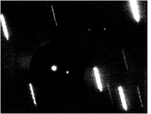 Pluton et ses trois satellites. La luminosité de la planète naine a été ici réduite afin de permettre cette vue d'ensemble du système.
