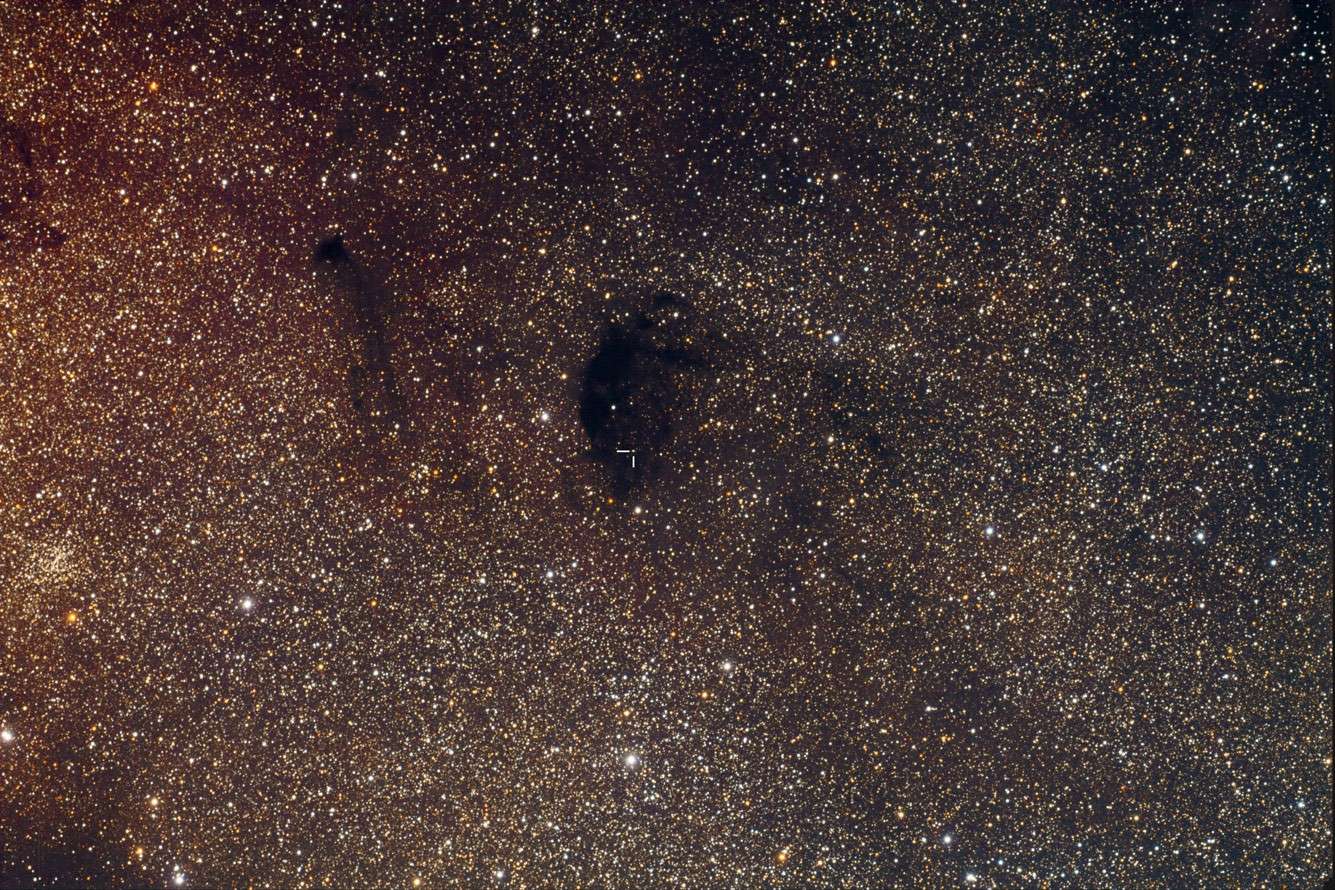 Dans ce nuage d'étoiles du Sagittaire, l'astrophotographe Ray Gralak a débusqué la modeste Pluton (indiquée par deux petits traits) alors qu'elle se trouvait devant la nébuleuse sombre Barnard 92. Crédit R. Gralak