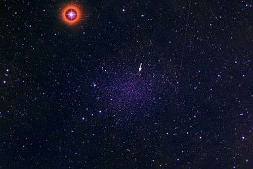 La galaxie naine du Sculpteur, une flèche blanche indiquant la position de MAG 29. Crédit : Palomar Digitized Sky Survey-Cornell University