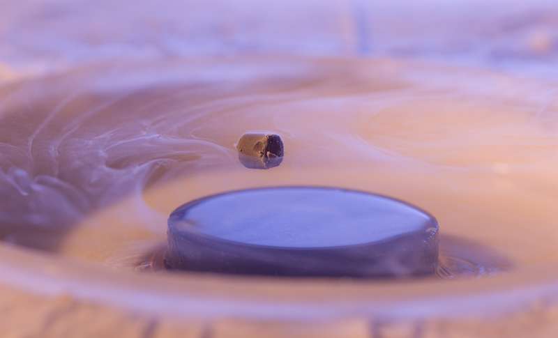Un exemple d'un aimant flottant au-dessus d'un supraconducteur. L'état supraconducteur a été obtenu en versant de l'azote liquide sur le matériau sous l'aimant. © François Jannin / CNRS Photothèque