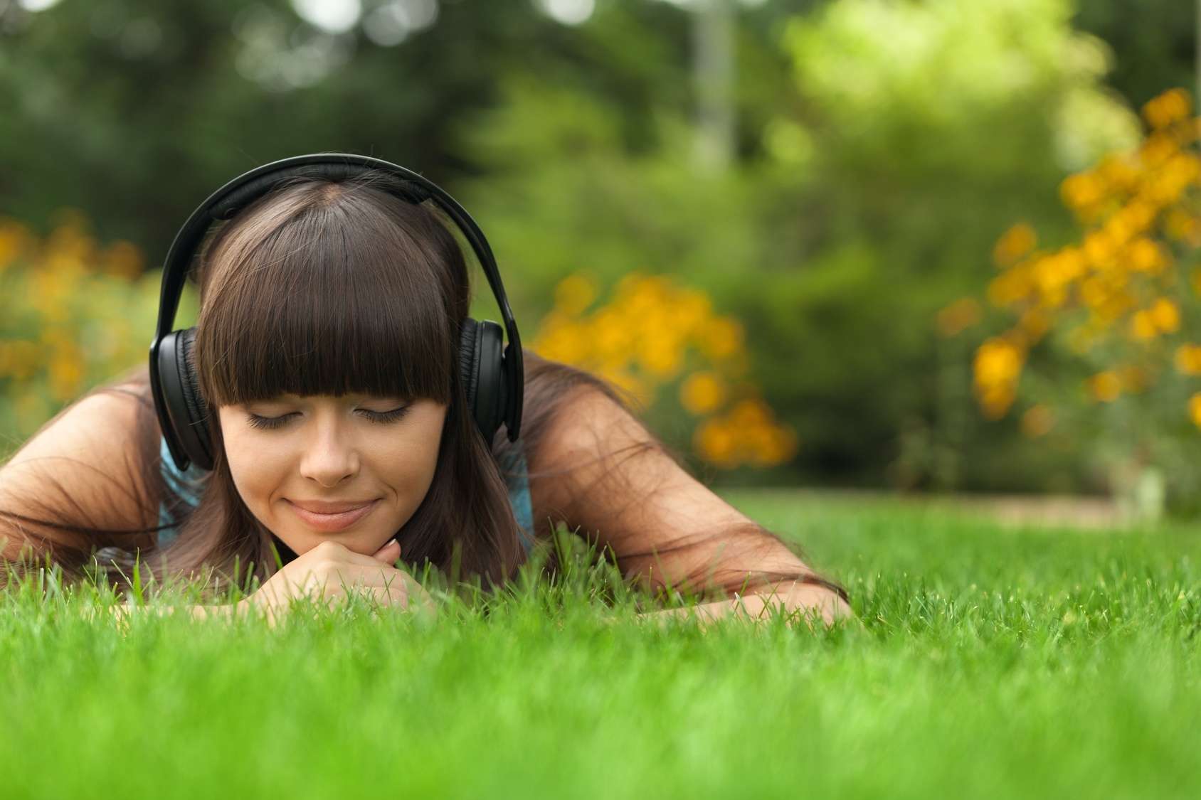 Слушать музыку меняй. Женщина слушает музыку. Человек слушает музыку. Картинка девушка слушает музыку. Девушка в наушниках на траве.