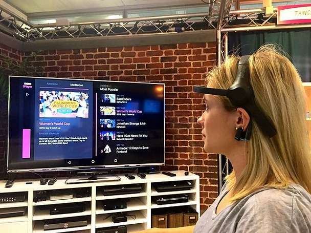 La chaîne britannique BBC a mis au point un prototype de système de contrôle par la pensée pour remplacer la télécommande du téléviseur. Muni d’un casque EEG, la personne concentre son attention sur l’application et le programme qu’elle souhaite visionner. © BBC