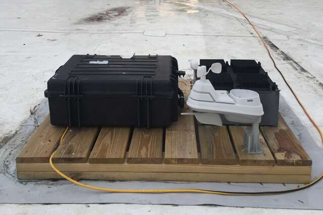 Le prototype a été installé sur le toit du MIT, où il a été testé plusieurs mois sur des périodes d’environ 15 jours. On peut l’entrevoir, en noir à droite de l’image, derrière une station météorologique en blanc, et à côté d’un appareil de mesure, en noir à gauche. © Justin Raymond, MIT