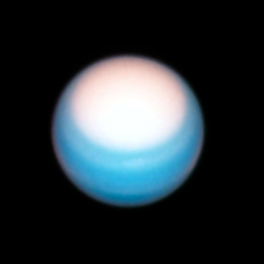 Une vue d'Uranus prise par Hubble le 25 octobre 2021 met en lumière la brillante « calotte » polaire nord de la planète. C'est le printemps dans l'hémisphère Nord et l'augmentation du rayonnement ultraviolet du Soleil semble provoquer l'éclaircissement de la région polaire. Les chercheurs ne savent pas vraiment pourquoi. Il pourrait s'agir d'un changement dans l'opacité du brouillard de méthane atmosphérique ou d'une certaine variation dans les particules d'aérosol. Curieusement, alors même que la calotte atmosphérique devient plus lumineuse, la limite la plus nette au sud reste à la même latitude. Cela a été constant au cours des dernières années d'observations de la planète par Hubble. Peut-être qu'une sorte de jet stream met en place une barrière à cette latitude de 43 degrés. © Nasa, ESA, A. Simon (Goddard Space Flight Center) et M.H. Wong (Université de Californie, Berkeley) et l'équipe OPAL