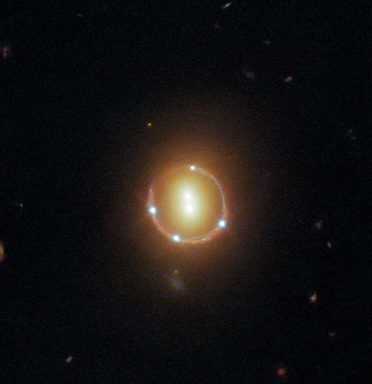 Gros plan sur l'anneau d'Einstein photographié par Hubble. Au centre : deux galaxies dont la masse dévie la lumière provenant du lointain quasar 2M1310-1714, à l'arrière-plan. Celui-ci est visible cinq fois sur cette image : les quatre points sur l'anneau et un cinquième en plein centre. © ESA, Nasa, Hubble, T. Treu