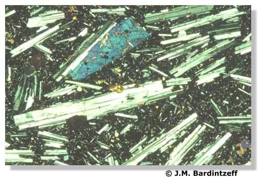 Lame mince de basalte vu au microscope polarisant. Un pyroxène apparaît teinté en bleu et les plagioclases sont rayés noir et blanc. © J.-M. Bardintzeff