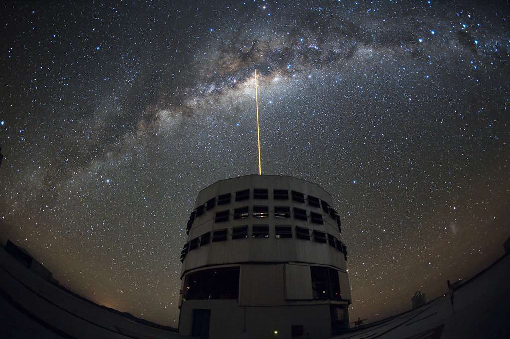 Cette image impressionnante, prise le 10 mai 2010 par l'astronome Yuri Beletsky, montre le ciel au-dessus de Paranal ainsi que Yepun, l'un des télescopes de 8,2 mètres du Very Large Telescope de l'ESO. En toile de fond on voit la Voie lactée avec un faisceau laser sortant de Yepun, visant parfaitement le centre galactique. De cette manière l'état de turbulence de l'atmosphère est sondé afin de faire des corrections d'optique adaptative pour observer finement le centre de notre galaxie. © Yuri Beletsky-ESO