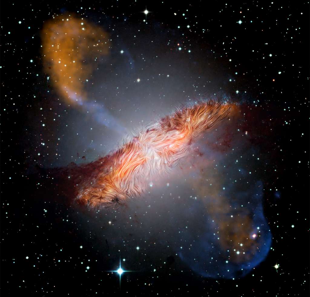 Les champs magnétiques observés par Sofia sont représentés sur une image de la galaxie prise à des longueurs d’onde visibles et submillimétriques par l’European Southern Observatory et l’Atacama Pathfinder Experiment — en orange —, aux rayons X par Chandra — en bleu — et dans l’infrarouge par le télescope spatial Spitzer — en rouge foncé. © Optique : imageur grand champ de l’Observatoire austral européen (ESO) ; Submillimétrique : Max Planck Institute for Radio Astronomy / ESO / Atacama Pathfinder Experiment (APEX) /A.Weiss et al. ; Rayons X et infrarouges : Nasa, Chandra, R. Kraft ; JPL-Caltech, J. Keene ; Sofia, L. Proudfit