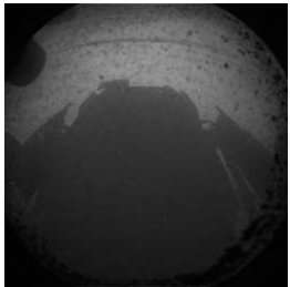 L'ombre de Curiosity sur le sol du cratère Gale le 6 août 2012 vers 5 h 31 en temps universel (TU) pour les Terriens. C'est l'une des toutes premières images expédiées par le rover qui vient de se poser sur Mars. Bien sûr, il y aura bientôt mieux que cette photographie monochrome en basse résolution... © JPL-Caltech, Nasa