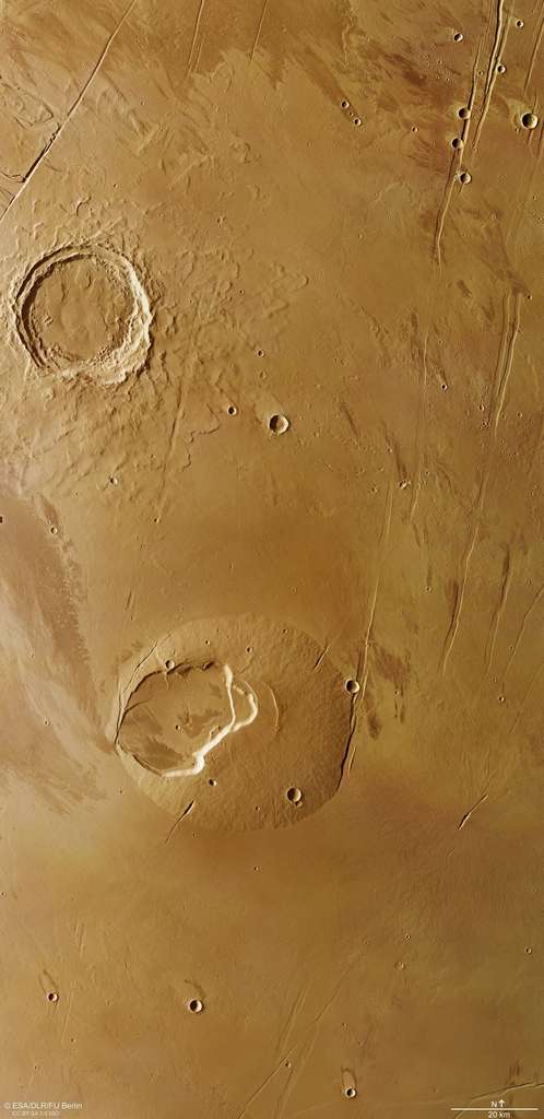 Mars Express dévoile de nombreux détails permettant de retracer l'histoire de cette région de Mars. Au centre, le volcan Jovis Tholus, au nord-ouest le cratère d'impact, bordé par une grande faille dont s'écoulent des traces de chenaux. © ESA, DLR, FU Berlin, CC by-sa 3.0 igo