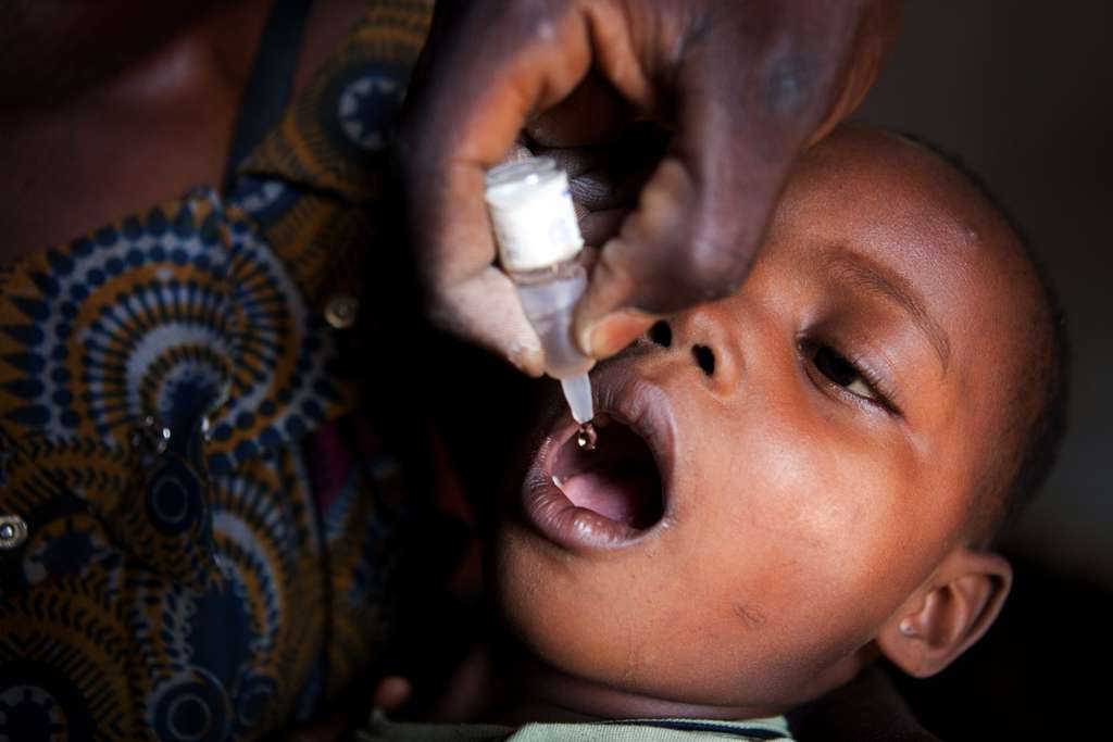 Une employée du ministère de la Santé de la RDC administre un vaccin contre la polio à un enfant congolais. © Gwenn Dubourthoumieu, AFP Photo