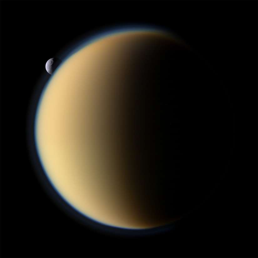 Titan, son épaisse atmosphère, et la petite lune glacée Tethys passant derrière Titan au moment où la sonde Cassini-Huygens réalise ce cliché le 26 novembre 2009. © Nasa/JPL/Space Science Institute