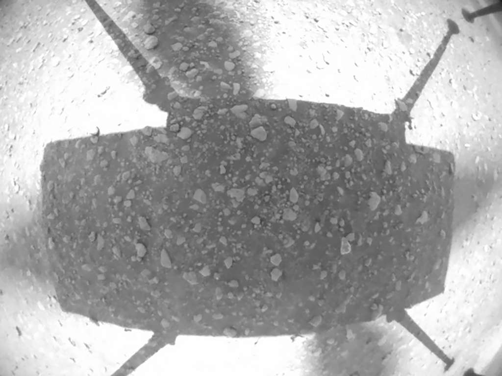 Poussière, grains et petits cailloux sous l'hélicoptère. Image acquise lors du deuxième vol d'Ingenuity. L'image montre l'ombre de l'hélicoptère sur le sol martien. © Nasa, JPL-Caltech