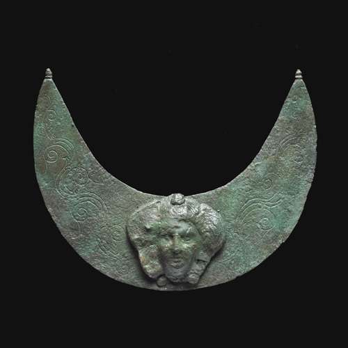 Croissant en cuivre et bronze décoré d'un visage féminin, en Afghanistan Croissant en cuivre et bronze décoré d'un visage féminin, en Afghanistan