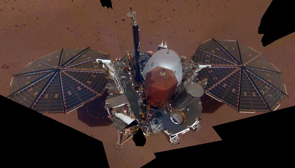Premier selfie de l'atterrisseur InSight capturé le 6 décembre 2018, peu après son arrivée sur Mars. De la poussière s'est déjà posée sur ses panneaux solaires mais ce n'est rien en comparaison avec son dernier selfie du 24 avril 2022. © Nasa, JPL-Caltech