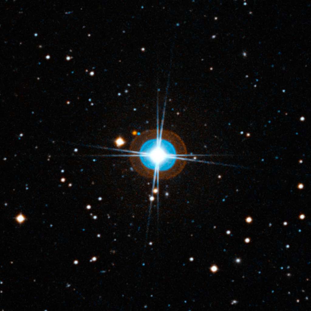 Gros plan autour de HD 10180. Comme la précédente, l'image a été créée à partir de photographies prises avec des filtres rouge et bleu. Les halos bleu et orange autour de l'étoile, et les huit pointes de lumière sont des artefacts. Le remarquable système planétaire autour de cette étoile est beaucoup trop proche d'elle pour être visible. Crédit : ESO, Digitized Sky Survey 2-Davide De Martin