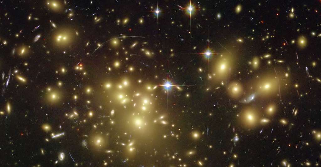 Sur cette image, on voit l'effet de lentille gravitationnelle fort de l'amas de galaxies Abell 2218. Même si cet effet est spectaculaire, ce n’est pas celui qu’il faut prendre en compte pour étudier le CMB et les neutrinos, mais l'effet faible. © Nasa