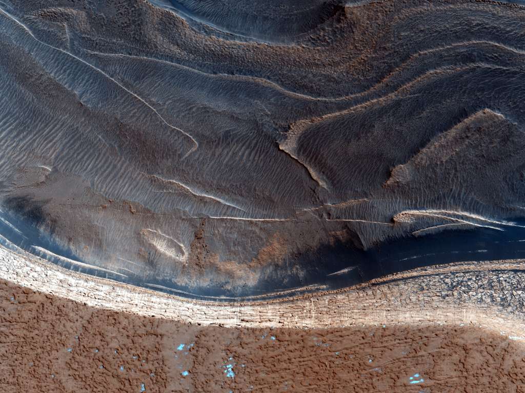 Des falaises de 800 m de haut bordent la calotte polaire nord qui atteint plusieurs kilomètres d'épaisseur au centre. Les internautes sont invités à rechercher la trace de rochers qui seraient tombés au pied de ces remparts. © Nasa/JPL/University of Arizona 