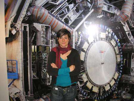 Jessica Leveque devant une photo du détecteur Atlas à l'intérieur du batiment abritant sa salle de contrôle. Crédit : Laurent Sacco, Futura-Sciences