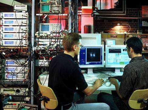 Les jeunes ordinateurs quantiques ont encore besoin de l'ancienne génération ! Ces deux étudiants de l'UIBK sont à la console d'ordinateurs conventionnels servant à piloter les lasers et les source radiofréquences d'un ordinateur quantique. © UIBK/C.Lackner - Tous droits de reproduction interdit