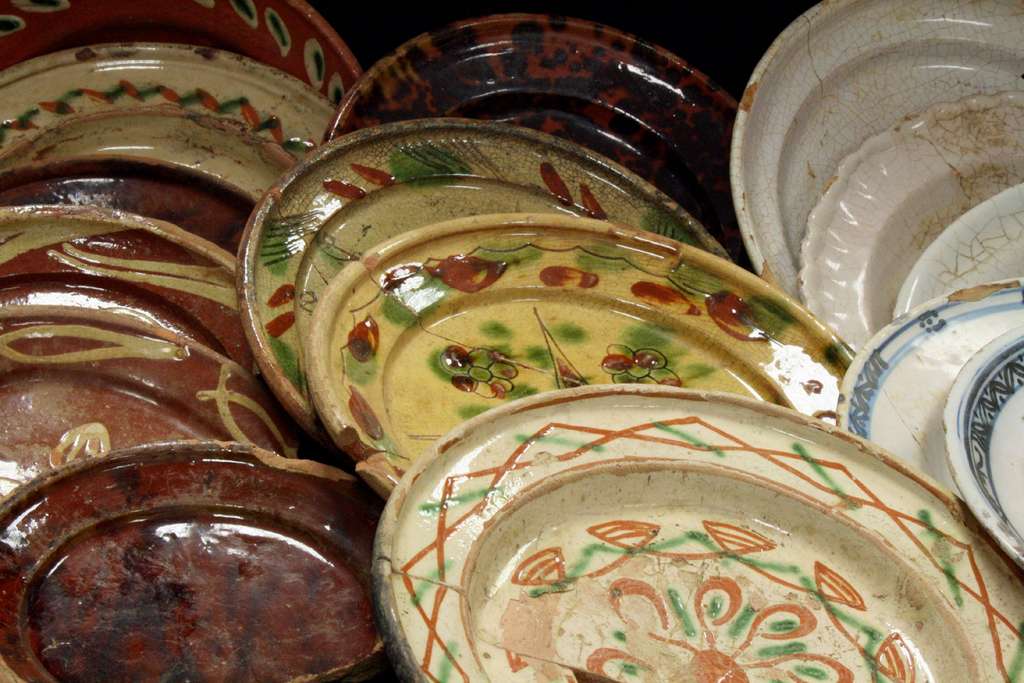 Des vaisselles de table hautes en couleurs : assiettes et écuelles en terre vernissée et faïence. © Inrap