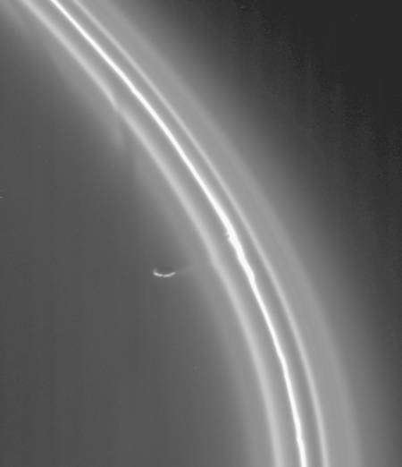 Cette image montre l'influence des forces de marée de Prométhée sur l'anneau F. Celui-ci est distordu et l'on note l'apparition d'ondulations et d'un courant de matière arraché à l'anneau. Cliquez pour agrandir. Crédit : Cassini imaging team Nasa
