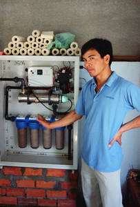 Chai Lo, co-fondateur de l’ONG 1001 Fontaines, devant le « placard de filtration d’eau » qu’il installe dans des villages de l’ouest du Cambodge. © Lionel Goujon et Gwenael Prié Chai Lo, co-fondateur de l’ONG 1001 Fontaines, devant le « placard de filtration d’eau » qu’il installe dans des villages de l’ouest du Cambodge. © Lionel Goujon et Gwenael Prié