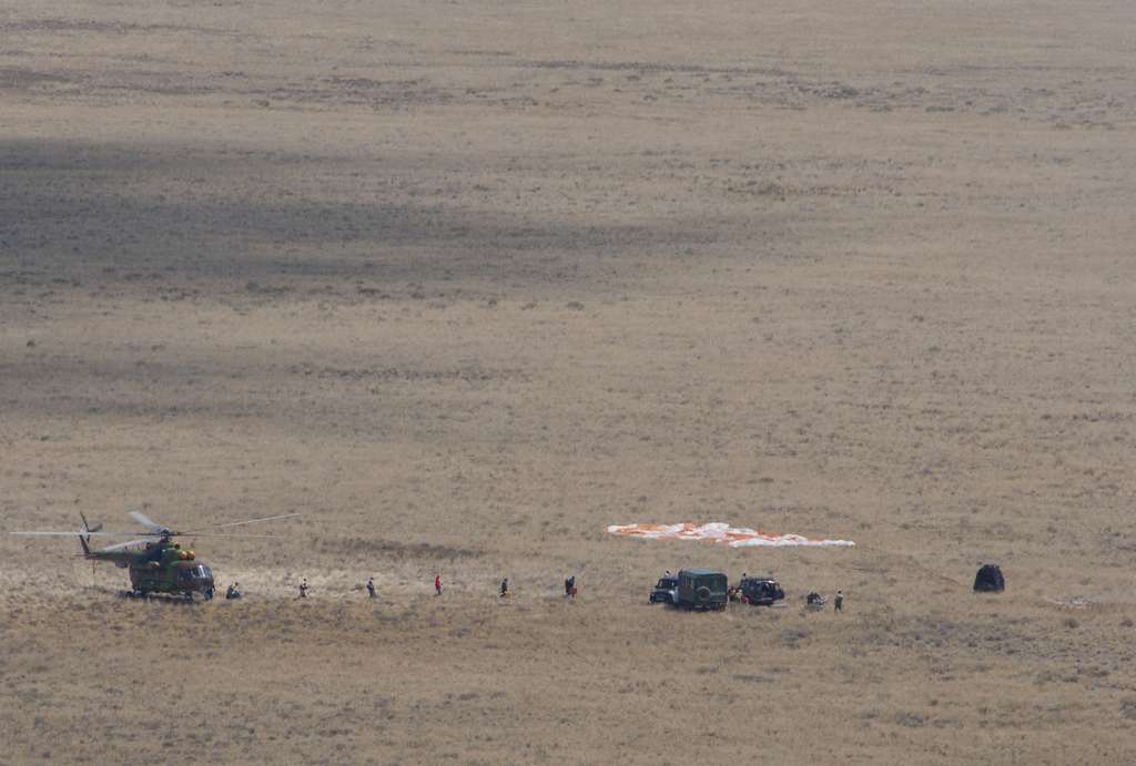 Dans les vastes steppes du Kazakhstan, une capsule Soyouz (à droite) posée au sol, après son atterrissage. © ESA, S. Corvaja