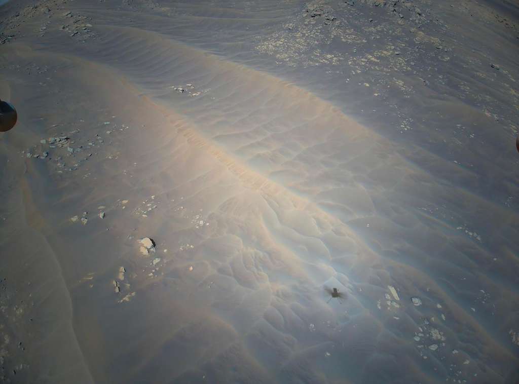 Cette image acquise par Ingenuity en vol résume bien l'un des intérêts d'utiliser un engin volant (drone hélicoptère par exemple) dans le ciel de Mars. Plutôt que d'essayer de franchir ces dunes de sables qui sont la hantise des pilotes du rover, lequel pourrait s'ensabler, un hélicoptère peut être utilisé pour juger du fort intérêt ou non des roches qui se trouvent au-delà de ces dunes sables. © Nasa, JPL-Caltech