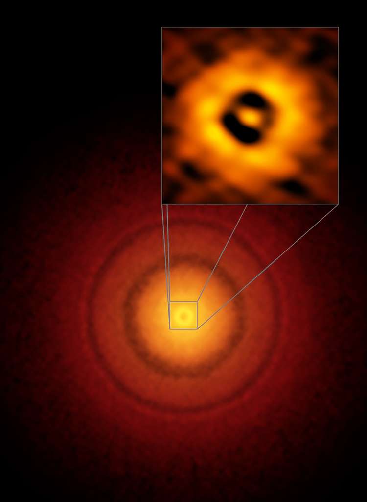 Image d’Alma du disque protoplanétaire autour de la jeune TW Hydrae que l’on a la chance de voir du dessus. L’encadré en haut à gauche agrandit sur l’anneau sombre le plus proche de l’étoile. Sa distance est équivalente à celle entre la Terre et le Soleil. Peut-être s’y cache-t-il un embryon d’une Terre ou d’une super-terre ? © S. Andrews (Harvard-Smithsonian CfA), Alma (ESO/NAOJ/NRAO)
