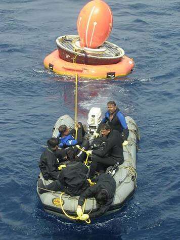 Remorquage du satellite SRE-1 en mer par une équipe de garde-côtes. Crédit ISRO.
