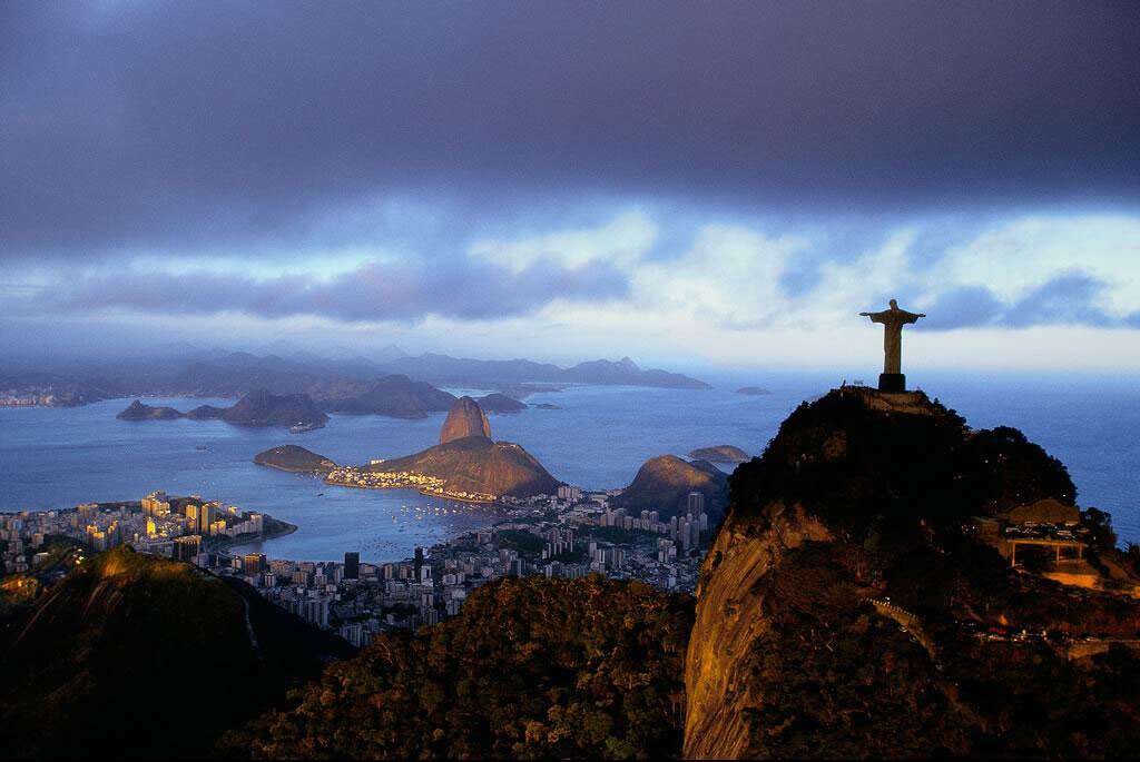 Le Corcovado surplombant la ville de Rio de Janeiro, Brésil (22°57’ S - 43°13’ O). Perchée sur un piton rocheux de 704 m appelé Corcovado (« bossu »), la statue du Christ rédempteur domine la baie de Guanabara et son célèbre « Pain de Sucre », ainsi que l’ensemble de l’agglomération de Rio de Janeiro. C’est à une méprise des premiers navigateurs portugais qui jetèrent l’ancre dans la baie, en janvier 1502, que la ville doit son nom de « fleuve de janvier », ces derniers croyant pénétrer dans l’embouchure d’un grand cours d’eau ou – autre hypothèse – celle d’une mauvaise transcription de « ria » (qui signifie baie en portugais). © Yann Arthus-Bertrand - Tous droits réservés