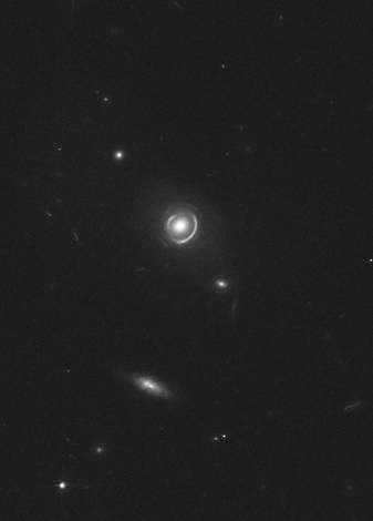 Une première galaxie, à trois milliards d'années-lumière, fait office de lentille. Elle nous montre deux anneaux presque concentriques, images déformées mais instructives de deux autres galaxies situées derrière, beaucoup plus loin dans l'axe de visée, à six et onze années-lumière. Cliquez pour agrandir. Crédit : Esa/Nasa