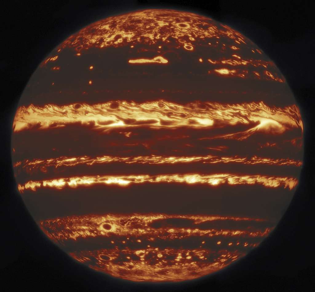 Jupiter vue en infrarouge par l'observatoire Gemini. Cette image a été compilée à partir d'une mosaïque de 9 pointages réalisés le 29 mai 2019. Chaque pointage consistait en 38 poses d'« imagerie chanceuse », dont les 10 % des meilleures furent conservées pour chaque neuvième du disque de Jupiter. Bien que la prise de chaque image ne prenne que quelques secondes, les 38 poses d'un pointage peuvent prendre plusieurs minutes, ce qui est suffisant pour que certaines structures se déplacent de façon notable sur le disque. Pour comparer et combiner les images, elles sont d'abord associées à leurs latitude et longitude réelles sur la planète en utilisant le bord du disque comme référence. Les images finales ont une résolution parmi les meilleures jamais obtenues en infrarouge de Jupiter depuis le sol. © International Gemini Observatory, NOIRLab, NSF, AURA, M.H. Wong (UC Berkeley)