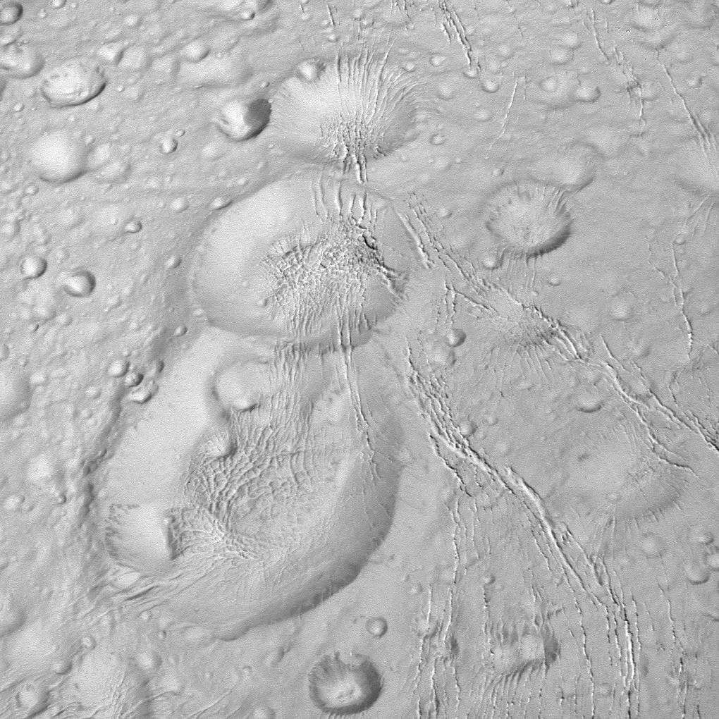Trio de cratères traversés de fissures visibles dans la région proche du pôle nord d’Encelade. Cette image a été prise par Cassini le 14 octobre 2015, à environ 10.000 km de la surface. © Nasa, JPL-Caltech, Space Science Institute