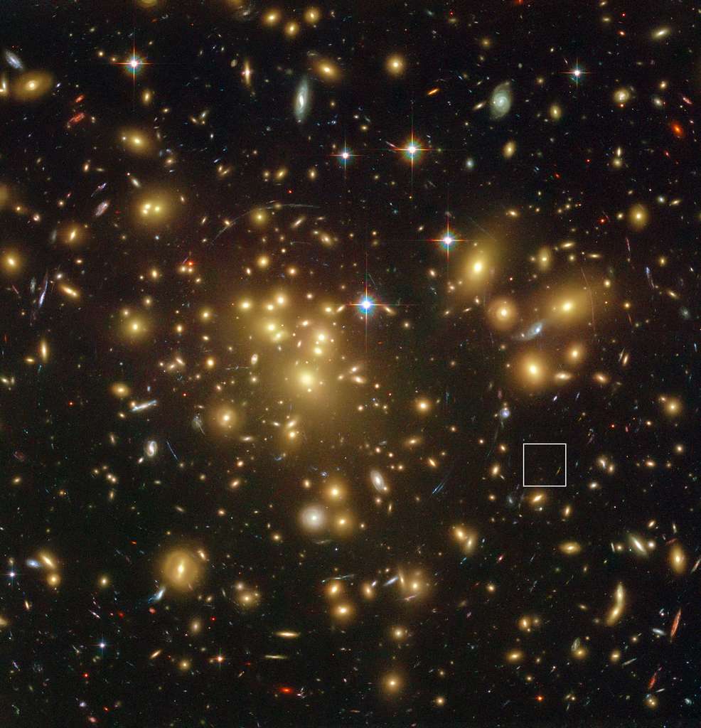 L’immense et massif amas de galaxies Abell 1689 photographié par Hubble. La lumière d'objets plus distants est déviée par l’énorme concentration de galaxies, ce qui peut augmenter leur luminosité au point de les rendre visibles comme dans le cas de l'objet A1689-zD1 (encadrement à droite). Sa luminosité a été amplifiée d’un facteur 9. Son décalage vers le rouge (redshift) est de 7,5. © Nasa, Esa, L. Bradley et H. Ford (Johns Hopkins University), R. Bouwens et G. Illingworth (University of California)