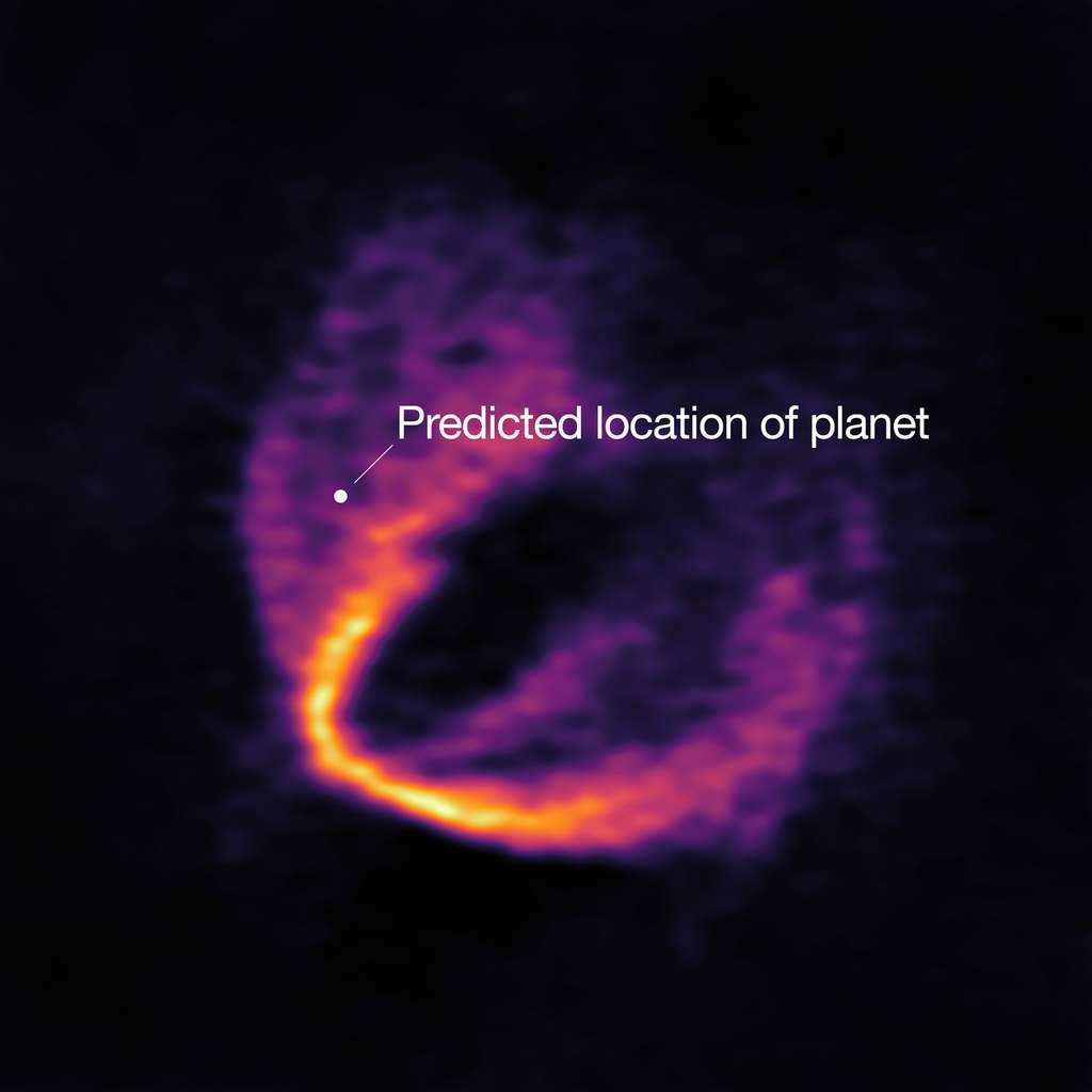 Localisation de la protoplanète découverte par l'équipe française. Sur cette image figure une partie de l’ensemble des données d’Alma. La déformation du disque de matière, bien visible, indique clairement la présence de l’une des planètes dont l’emplacement est marqué d’un point. © ESO, Alma (ESO/NAOJ/NRAO), Pinte et al.