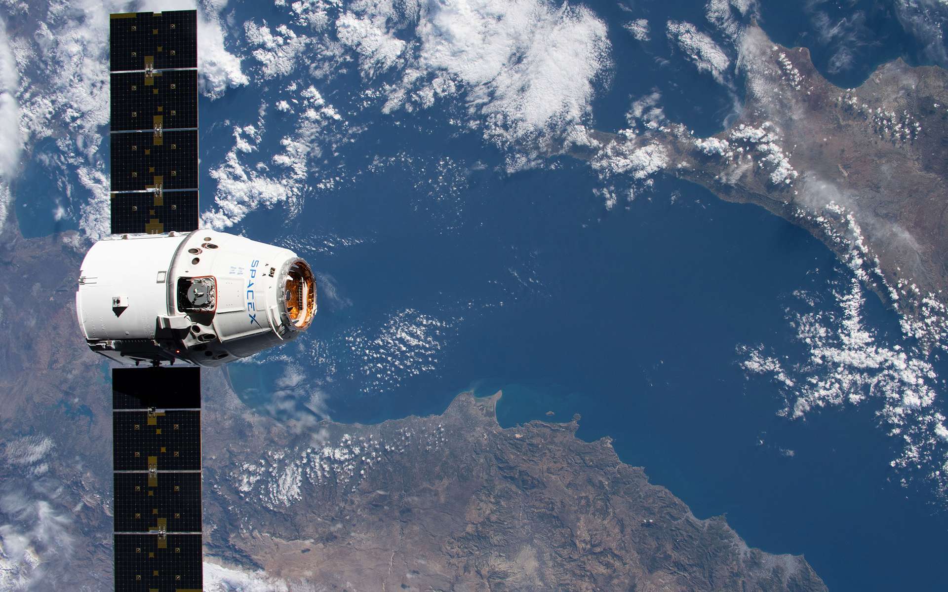 Un véhicule cargo Dragon de SpaceX en vol pour ravitailler la Station spatiale internationale. Toucan Space utilisera ce moyen de transport spatial pour envoyer ses objets et ceux de ses clients à bord de l'ISS. © Nasa