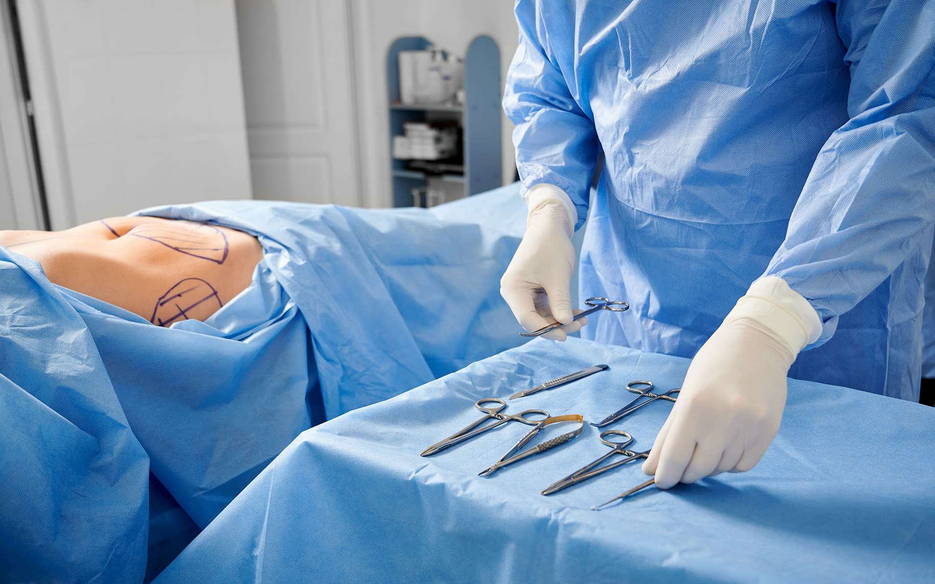 Chirurgien en gants stériles préparant des instruments médicaux, prêt à intervenir sur un patient. © Anatoliy_gleb, Adobe Stock