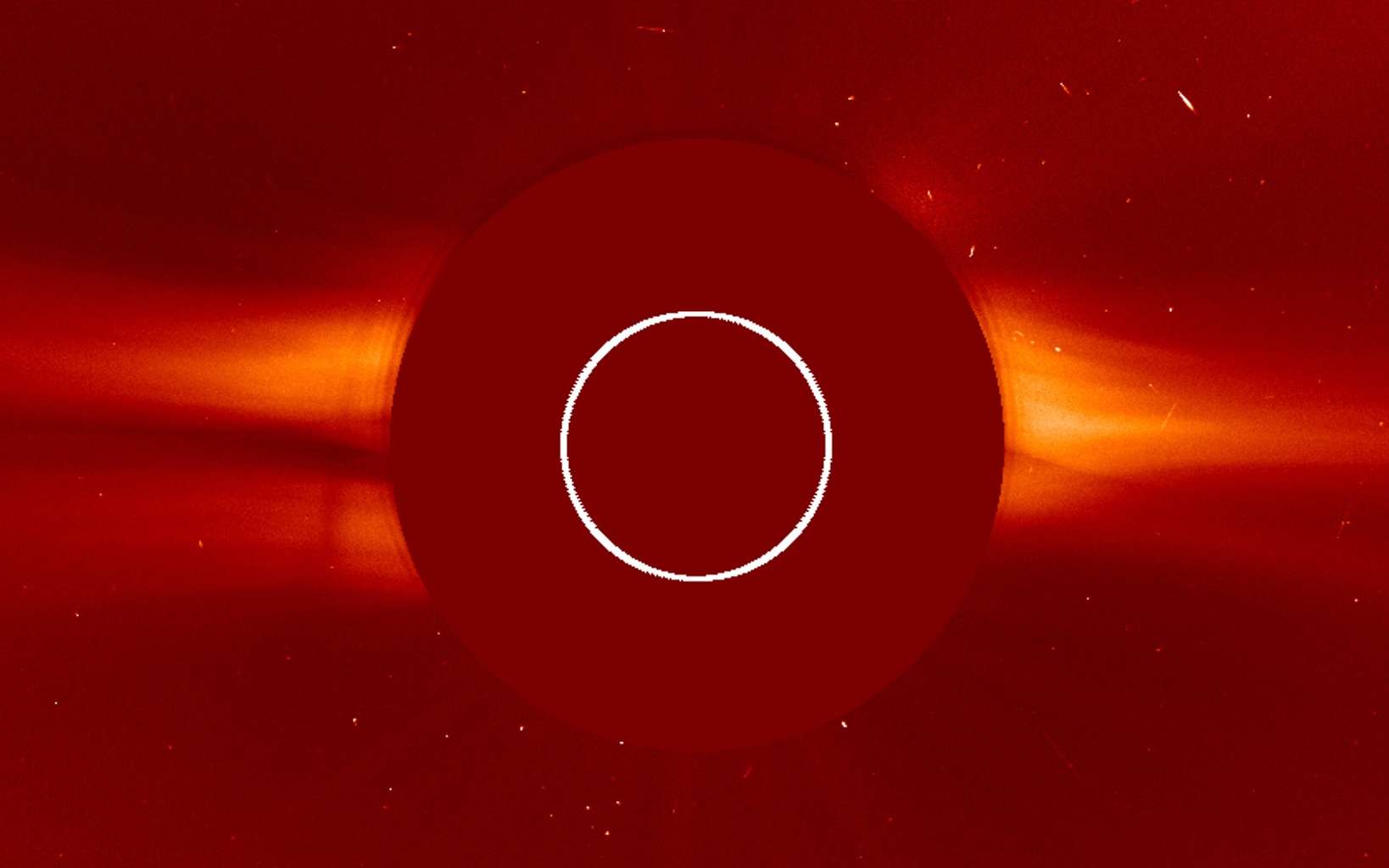 Le Soleil est au centre masqué par le coronographe Lasco C2 du satellite Soho. Image du 14 août 2020. On peut voir le vent solaire dépasser du disque. Le cercle blanc délimite la taille du Soleil. © Nasa, ESA, Soho
