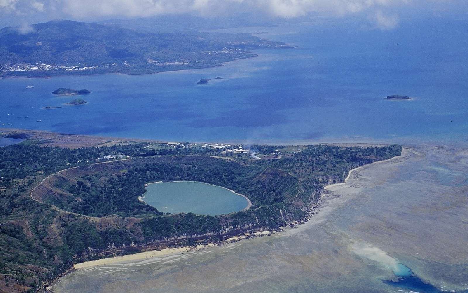 Photo aérienne du lac Dziani qui est le vestige d'un des derniers cratères volcaniques de Mayotte (éteint il y a environ 500.000 ans). C'est à son pied, à une cinquantaine de kilomètres du rivage et 3,5 km de profondeur, qu'est apparu le nouveau volcan sous-marin début 2019, responsable de nombreux séismes. © Franck Bouttemy http://www.geodiversite.net/auteur197, Wikimedia Commons, CC by-sa 3.0