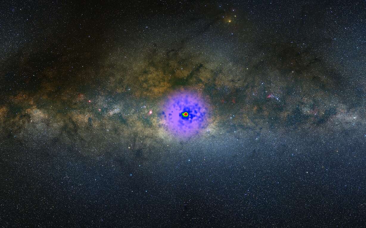 Les observations de Fermi montrent un excès de rayons gamma au cœur de la Voie lactée. Elles sont surimposées en fausses couleurs à une image dans le visible sur ce montage photographique. © Nasa