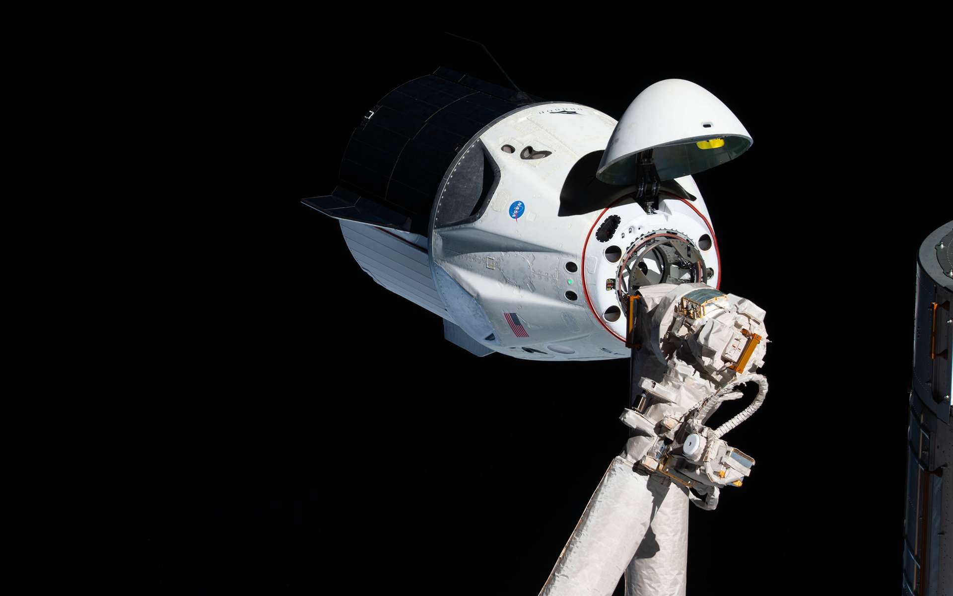 Amarrage du Crew Dragon à la Station spatiale internationale lors de son premier vol démonstration. La capsule de SpaceX, inhabitée pour ce vol, s'est arrimée de façon automatisée au complexe orbital (mars 2019). © Nasa