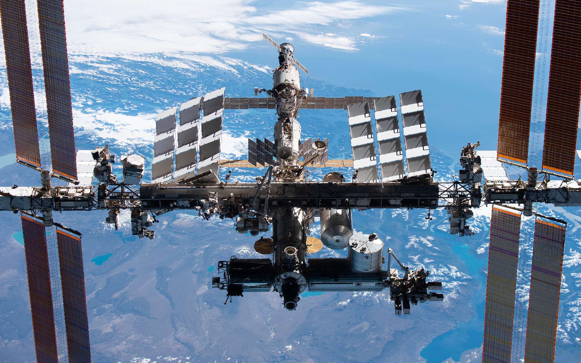La Station spatiale internationale en novembre 2021 vue depuis la capsule Crew Dragon de SpaceX. Le segment russe se situe en haut de l'image. À l'ombre, la partie occidentale. © Nasa