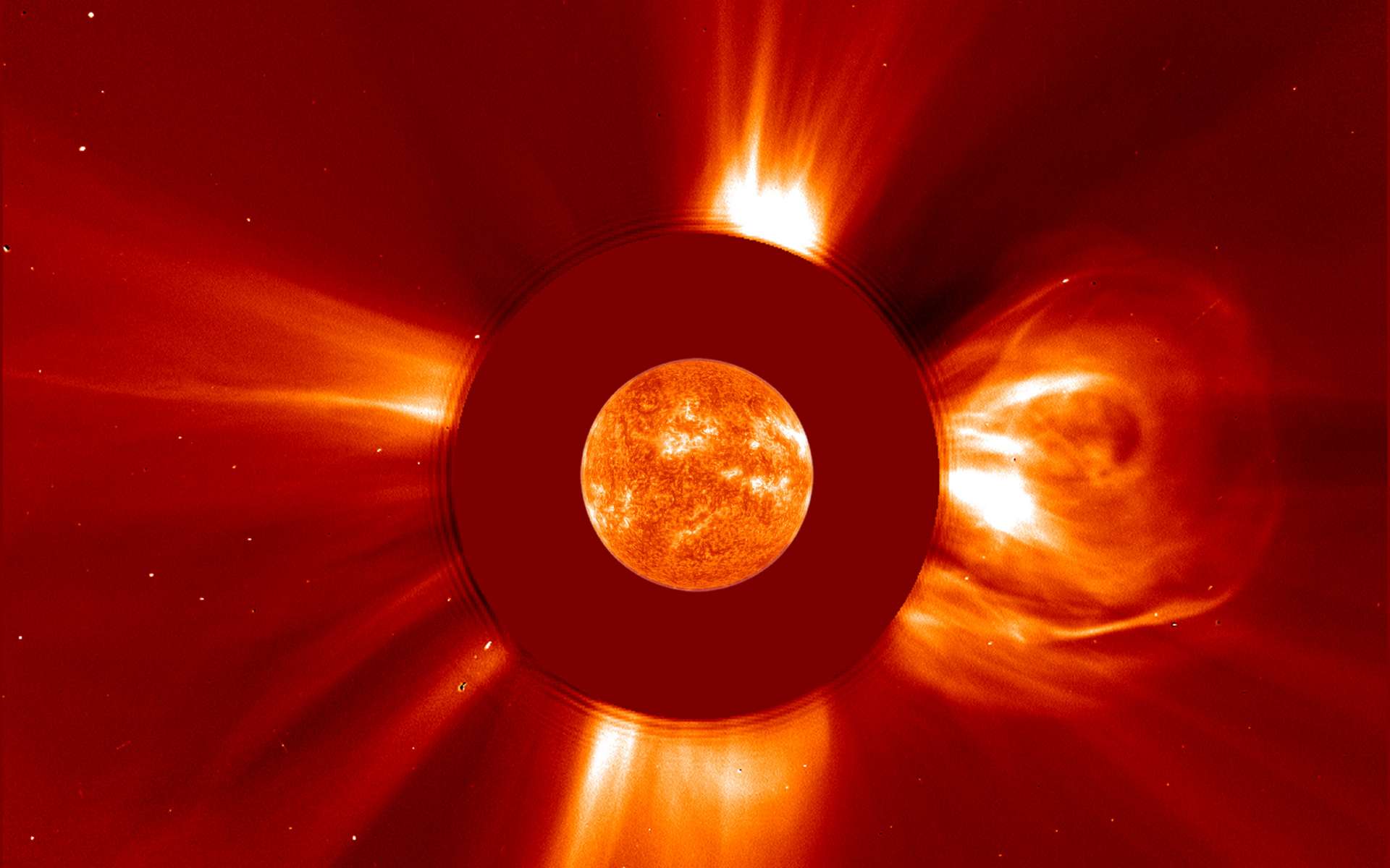 Bourasques de vent solaire imagées par le satellite Soho en avril 2001. Le Soleil au centre a été observé avec un autre instrument et superposé sur le disque noir de Lasco C2 qui masque le Soleil. © Nasa, ESA, Soho