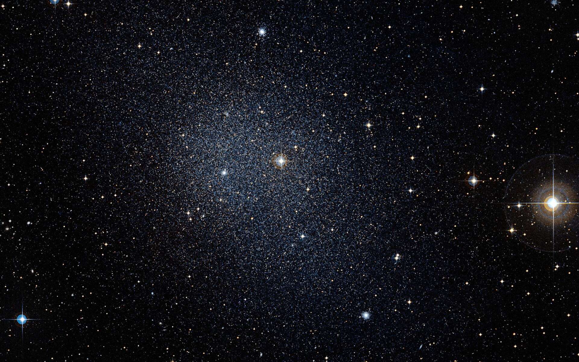 Distante d’environ 450.000 années-lumière, la galaxie du Fourneau est une des galaxies naines capturées par les forces gravitationnelles de la Voie lactée. Son destin est de se fondre dans notre grande communauté galactique. © Eso, DSS2