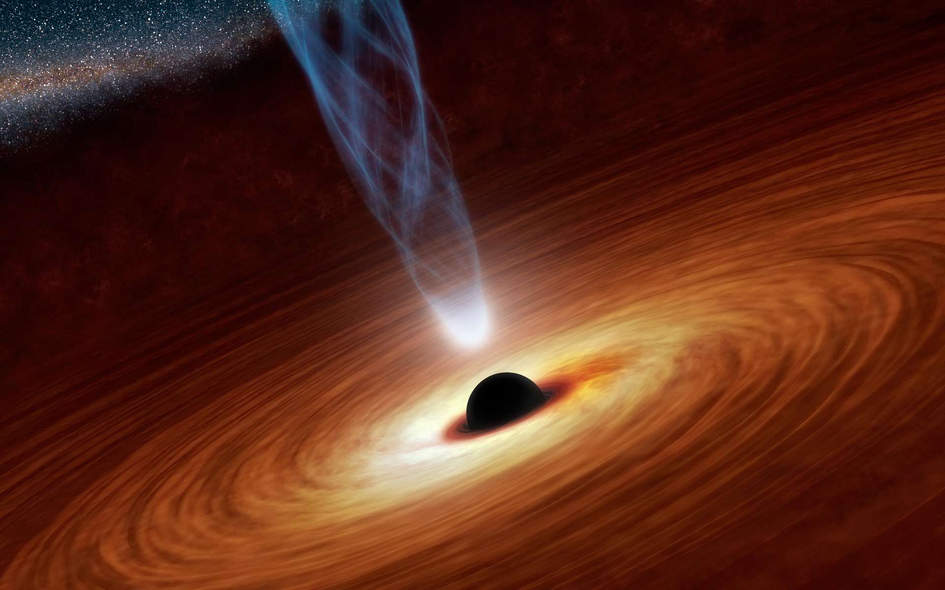 Cette vue d'artiste illustre un trou noir supermassif avec des millions à des milliards de fois la masse de notre Soleil. Les trous noirs supermassifs sont des objets extrêmement denses enfouis au cœur des galaxies. Dans cette illustration, le trou noir supermassif au centre est entouré de matière s'écoulant vers le trou noir et formant ce que l'on appelle un disque d'accrétion. On voit également un jet de particules énergétiques, censé être alimenté par la rotation du trou noir. © NASA/JPL-Caltech