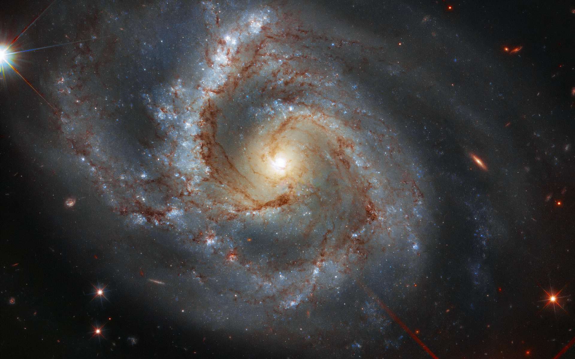 Difficile de préciser la structure de la Voie lactée dans laquelle nous vivons et sur laquelle nous n’avons donc pas de recul. Aussi difficile qu’il serait de décrire un avion en regardant par la fenêtre du hublot. Peut-être qu'elle resemble à NGC 7878, classée dans le catalogue des galaxies particulières au rayon de celles qui ont un « un bras lourd ». Située à 164 millions de kilomètres de la Terre, dans Pégase, elle est de dimension similaire à notre galaxie. © ESA, Hubble, NASA, A. Riess et al.