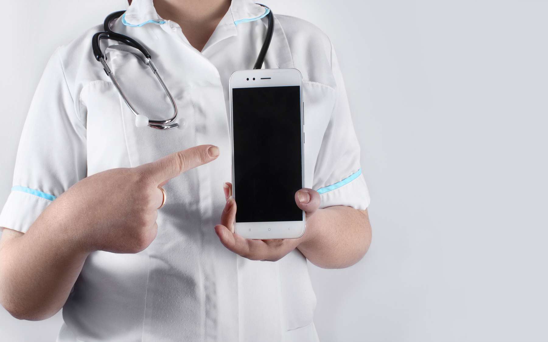 Un iPhone pointé du doigt par une médecin. © syberianmoon, Fotolia